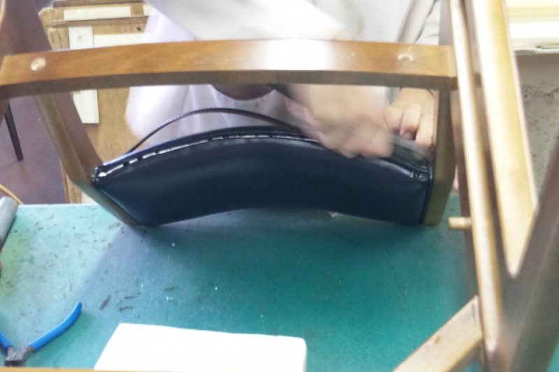 アームレスダイニングチェアの背もたれに玉縁を留める様子
